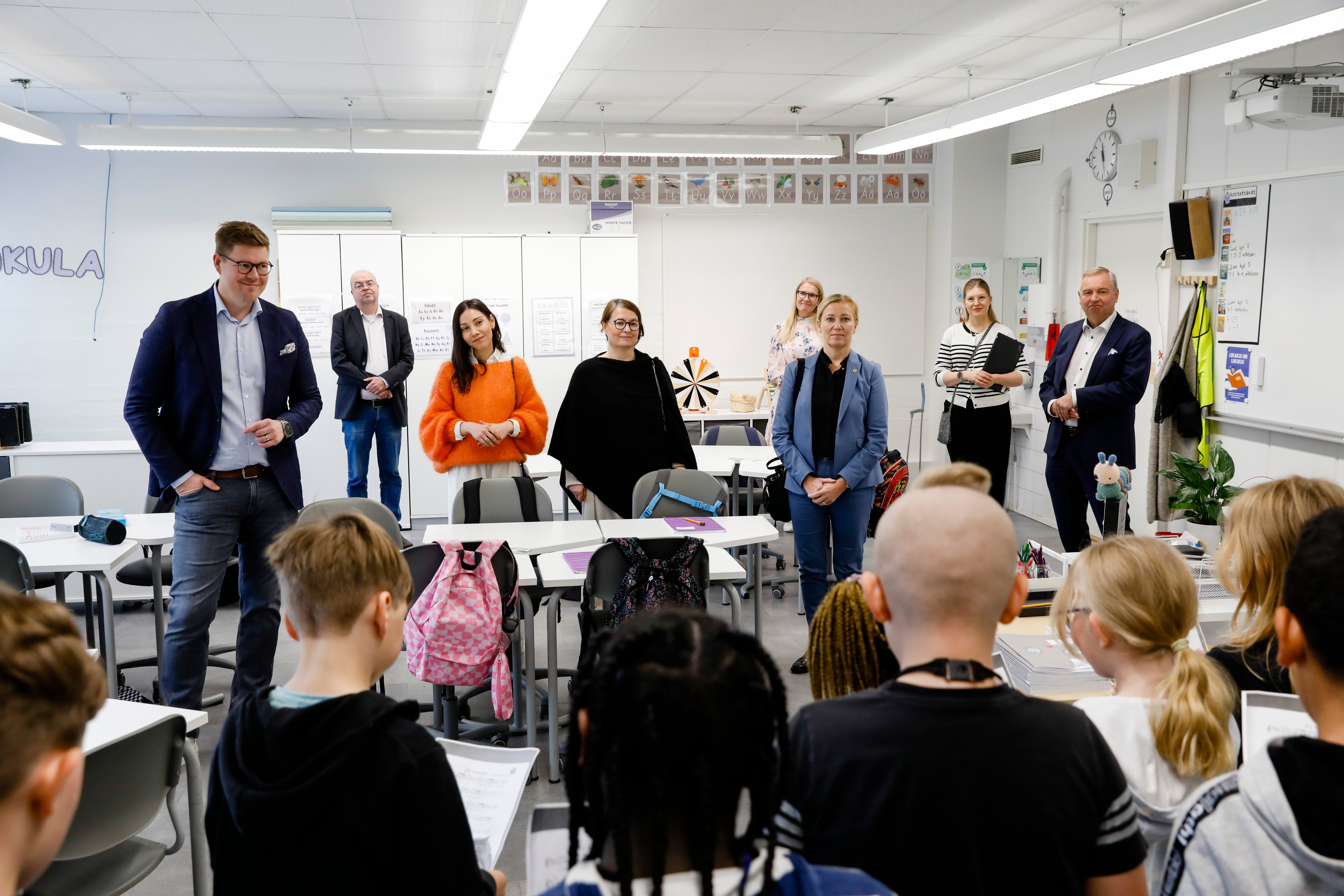 SDP:n puheenjohtaja Antti Lindtman, muita päättäjiä ja Katarina Murto Vantaan Lehtikuusen koulun luokassa muiden ihmisten kanssa.